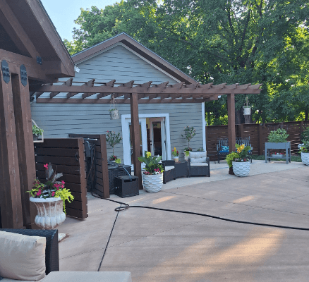 Outdoor patio with pergola and plants.