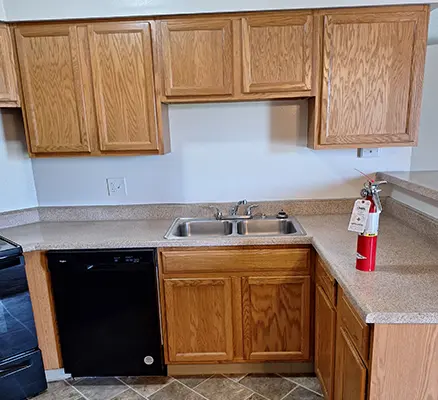 Kitchen with wooden cabinets and fire extinguisher.