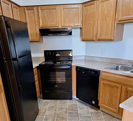 Small kitchen with black appliances and cabinets.